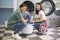 Happy Couple Doing Laundry Loading Washer Machine At Laundromat Room