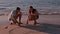 Happy couple drawing heart in the sand