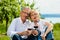 Happy couple drinking wine at lake in summer