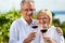 Happy couple drinking wine at lake in summer