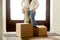 Happy couple embracing standing near boxes on moving day, close