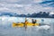 Happy couple enjoys ocean kayaking bear glacier during their vacation trip to in Alaska, USA