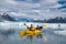 Happy couple enjoys ocean kayaking bear glacier during their vacation trip to in Alaska, USA.