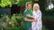 Happy couple expecting baby standing in garden in backyard