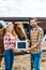 happy couple of farmers holding blackboard