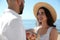 Happy couple with flowers at beach near sea. Honeymoon trip