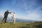 Happy couple goes on a mountain asphalt road in the woods on bikes with helmets giving each other a high five