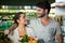 Happy couple with a grocery bag smiling at each other in organic section