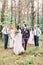 Happy couple with groomsmen and bridesmaids posing on wedding ceremony in the forest. Bride and groom with best friends