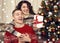 Happy couple having fun in christmas decoration at home. New year eve, ornated fir tree. Winter holiday and love concept.