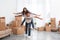 Happy couple having fun in room with cardboard boxes