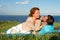 A Happy couple having fun on summer picnic outdoors and smiling.Beautiful couple laying on beach in grass.