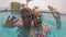 Happy couple having fun in swimming pool. Sending message to friends. Vacation summer. Action camera