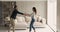 Happy couple holding hands dancing in modern living room