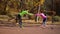 Happy couple holding hands and doing pair exercises on sports ground in autumn