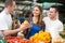 Happy couple holding pepper at a market stall