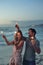 happy couple holding sparklers celebrating new years eve on beach at sunset with sparkle firework