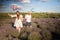 Happy couple holding surprise balloon during gender reveal party in lavender field.