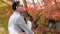 Happy couple hugging in the red maple autumn scene