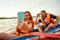 Happy couple kayaking on river with sunset on the background