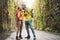 Happy couple kissing while exploring touristic park - Young tourist having fun doing excursion in wild forest