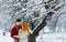 Happy couple is laughing and hugging during their walk along the snowy forest. Hald-length portrait.