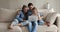 Happy couple and little daughter relax on sofa using laptop