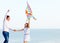 Happy couple in love with flying a kite on the beach