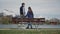 Happy couple in love standing together with hands raised on lakeside wooden bench with beautiful mountain view. Rear