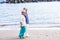 Happy couple in love together senior adults walking on the shore neat a quiet ocean waves. beach and peaceful vacation and