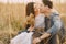 Happy couple in love in wheat field at sunset