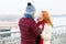 Happy couple loves walking in city. Rouge woman and man laughing on street. Man in blue hat makes funny rude women in red scurf