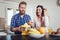 Happy couple make orange juice in morning kitchen