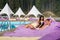 Happy couple - man and woman relaxing near swimming pool on cushioned loungers with drinks at the luxury resort
