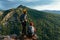 A happy couple in the mountains admires the beautiful views. Travelers enjoy climbing the mountain at sunset. Hiking