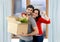 Happy couple moving together in a new house unpacking cardboard boxes