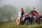 Happy couple near four-wheeler ATV in foggy nature