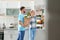 Happy couple with paper bag full of products standing near refrigerator