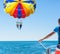 Happy couple Parasailing in Dominicana beach summer. Couple under parachute hanging mid air. Having fun. Tropical Paradise. Pos