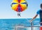 Happy couple Parasailing in Dominicana beach in summer. Couple under parachute hanging mid air. Having fun. Tropical Paradise. Pos