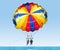 Happy couple Parasailing in Turkey beach in summer. Couple under parachute hanging mid air. Having fun. Tropical Paradise.