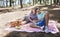 Happy couple, portrait and relax in nature for picnic, love or support in affection, date or outdoor bonding. Woman and