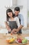 Happy couple preparing food at home, young couple cutting vegetables together at kitchen counter