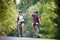 Happy couple ride on a mountain asphalt road on bikes