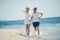 happy couple running on the sea beach