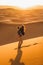 Happy couple Sahara desert dunes, Morocco. Happiness, freedom and escape concept