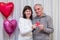 Happy couple seniors celebrate Valentine's Day. Man and woman hold red heart in hands and smile. Romantic relationships