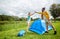 Happy couple setting up tent outdoors