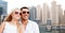 Happy couple in shades over dubai city background