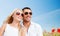 Happy couple in shades over poppy field background